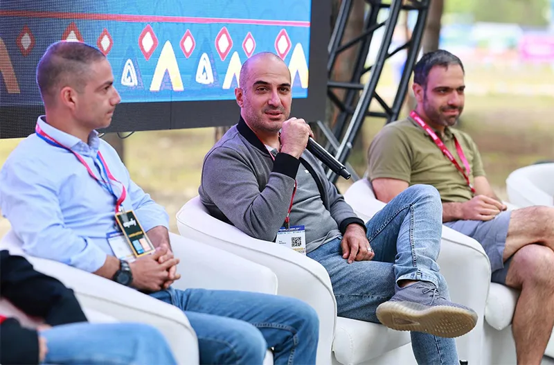 Rem Darbinyan speaking into a microphone on a festival panel