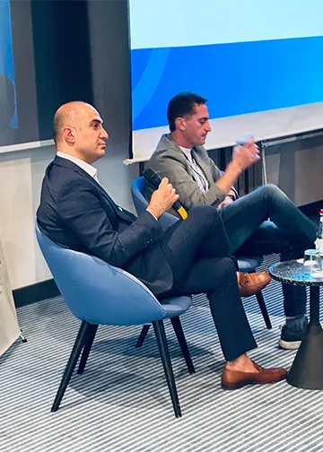 Rem Darbinyan seated on a panel in a conference room