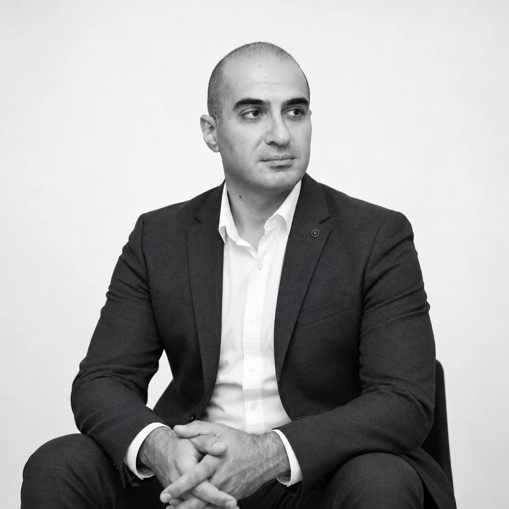 Black-and-white portrait of Rem Darbinyan seated in a dark suit, looking to the side
