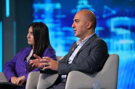Rem Darbinyan speaking on stage during a panel discussion